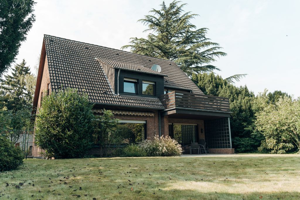 Außenansicht eines Einfamilienhauses mit Klinkerfassade und Gartengrundstück