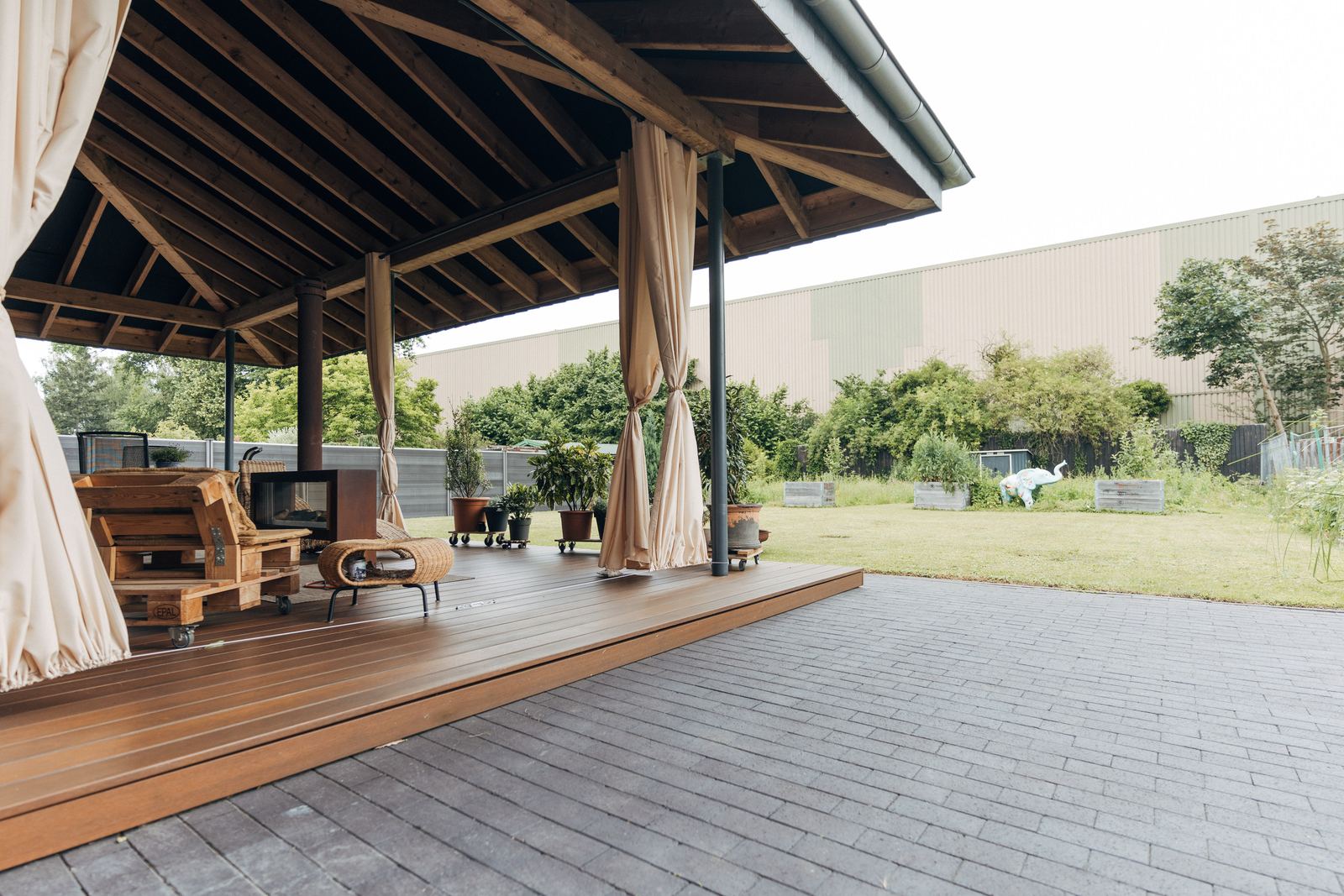 Überdachte Holzterrasse mit Blick in den Garten