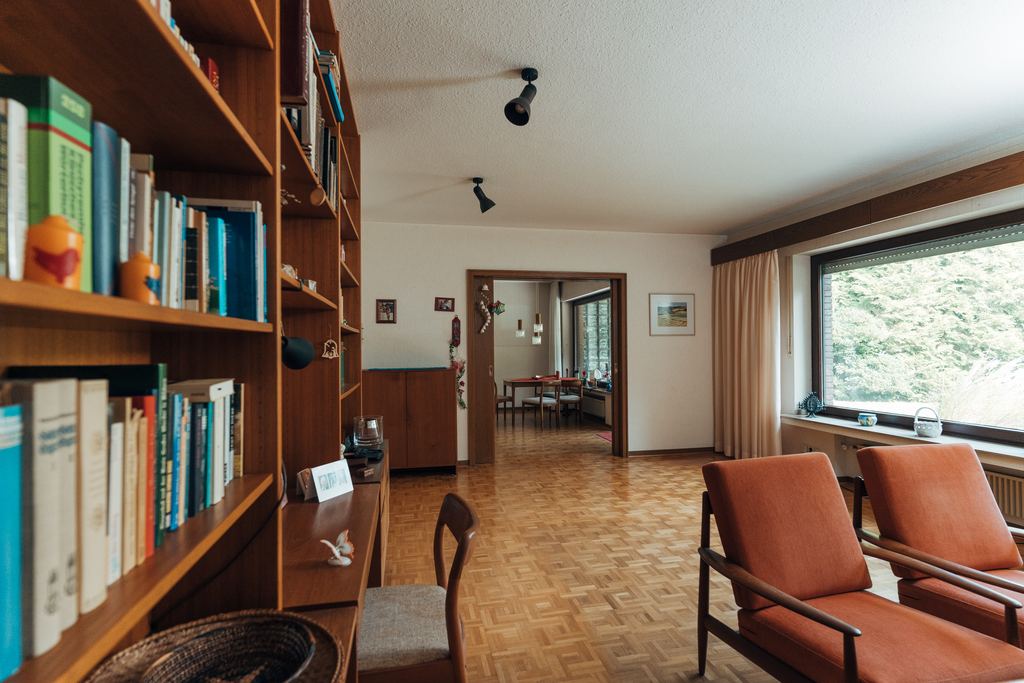 Wohnzimmer mit Teak-Bücherwand, Parkett und Blick in das Esszimmer